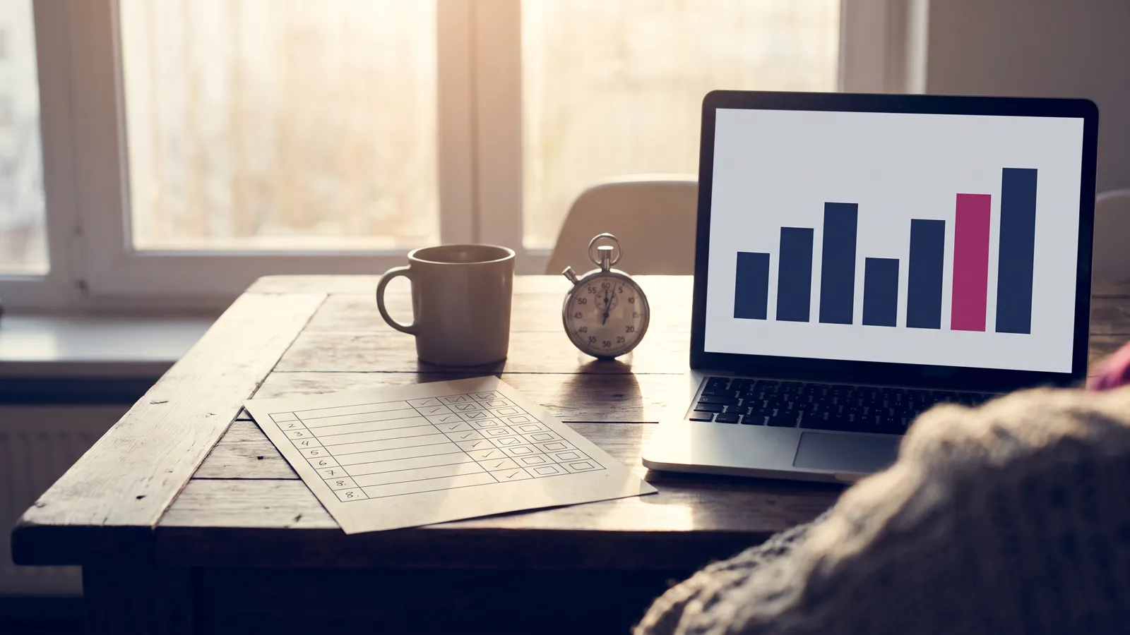 AI readiness assessment scorecard with eight scored rows on an office table beside a laptop and a one-hour timer